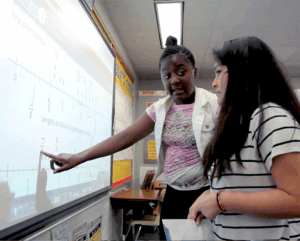student pointing at numberline on board