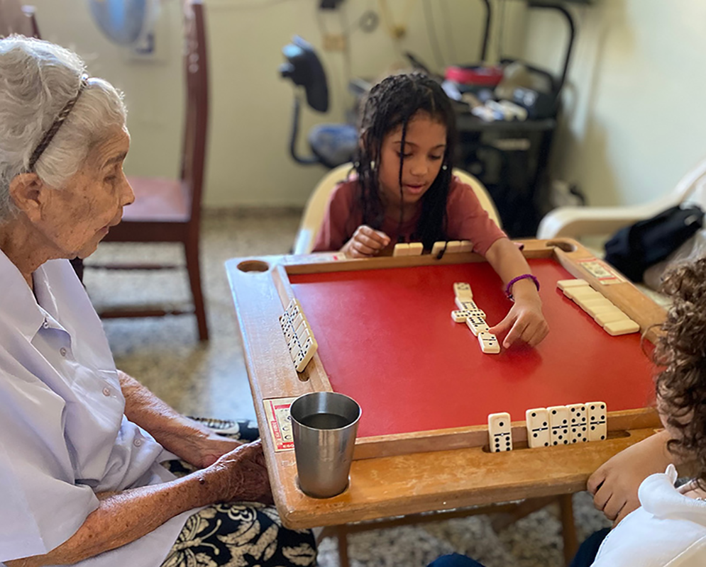 grandmother and kids playing dominoes